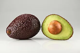 Whole and halved avocado showing persin-containing pit